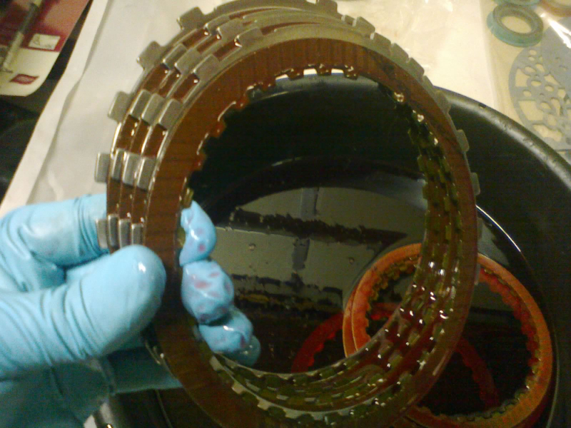 The friction plates have been soaking in ATF (+4) and can now be stacked with their steel plates. This is the LOW/REVERSE clutch pack.